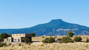 Een huis met een berg op de achtergrond.