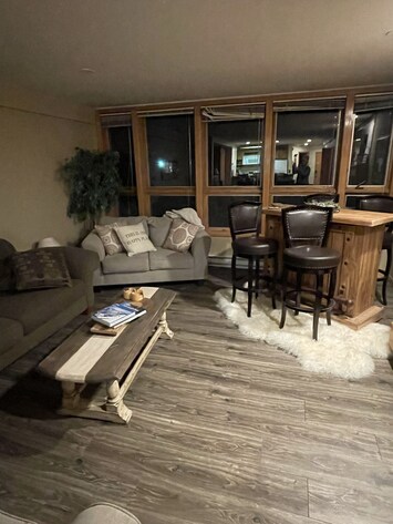 Spacious living area with 3 couches, TV, bar area and fireplace.