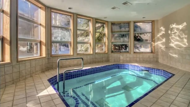 A swimming pool with a tiled floor and a metal ladder.