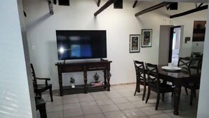 A living room with a TV, wooden furniture, and a tiled floor. - Cozy & Private Home at US Coral Reef Capital (Key Largo)