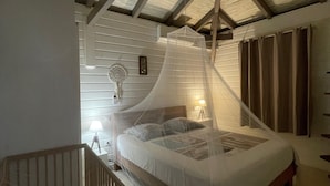 A bedroom with a canopy bed, wooden beams, a small balcony, and a bedside table with a lamp. - PROMO: CHARMING POOL VILLA LES TROIS ILETS 3 bedrooms sleeps 8. WATCH  (Les trois ilets)