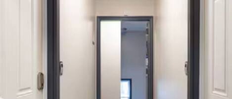 A narrow hallway with white doors on either side.