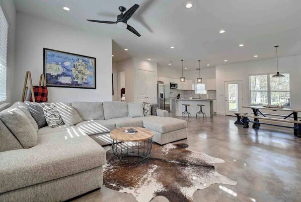 Relax in a spacious living area with a large sofa, coffee table, and dining space.