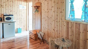 Una habitación con paneles de madera, una mesa de madera, un armario pequeño de madera y una silla.