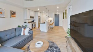 Un appartement moderne comprenant un salon, une cuisine et un coin repas.