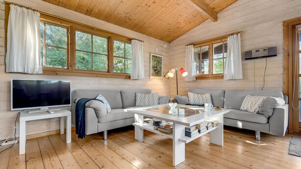 A cozy living room with a TV, sofa, coffee table, and bookshelves. - Cozy home in Bogø By with WiFi (Bogø By)