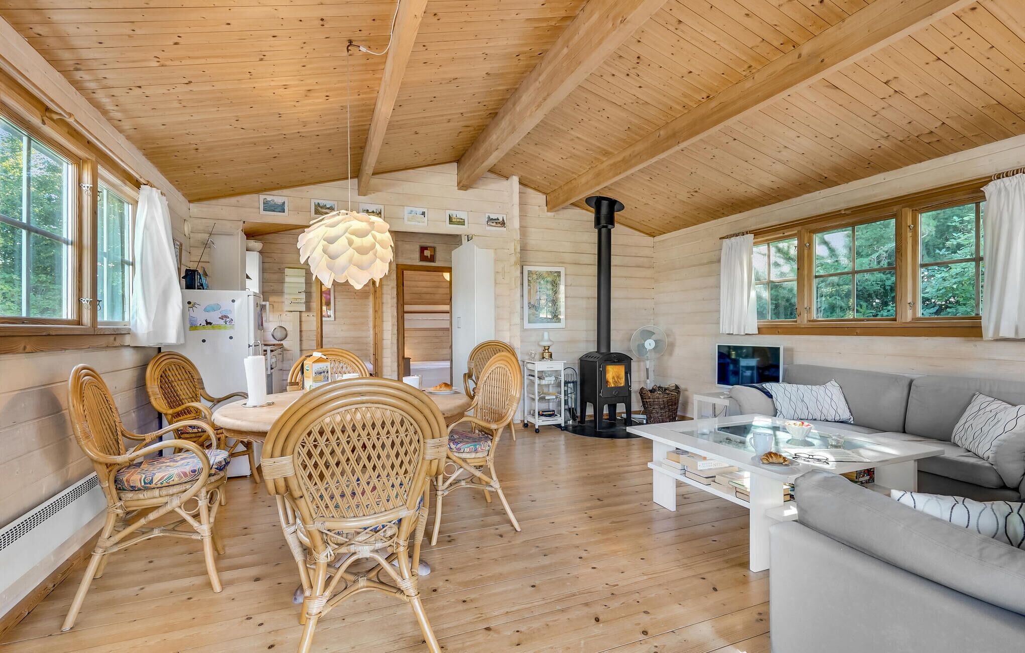 L’intérieur chaleureux d’un chalet avec un coin repas, un canapé et une cheminée.