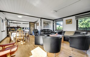 Relax in this stylish living space with a sofa, armchairs, and dining table.