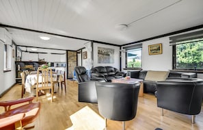 Relax in this stylish living space with a sofa, armchairs, and dining table.