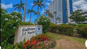 A sign for Gulfview 58 North with a view of a tall building and palm trees in the background. - Hello Sunshine!  Eat. Sleep. Beach. Repeat. (Marco Island)