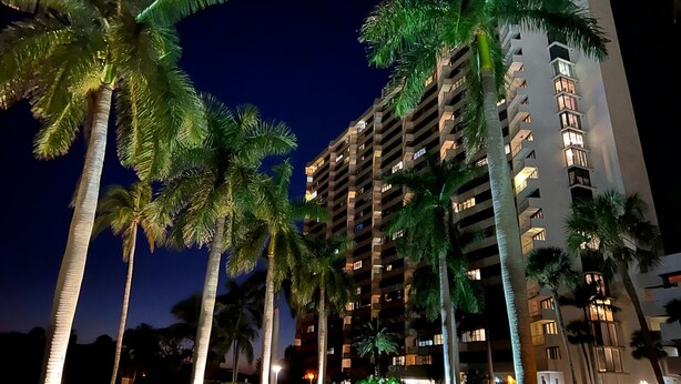A multi-story hotel with balconies and illuminated windows at night. - Hello Sunshine!  Eat. Sleep. Beach. Repeat. (Marco Island)