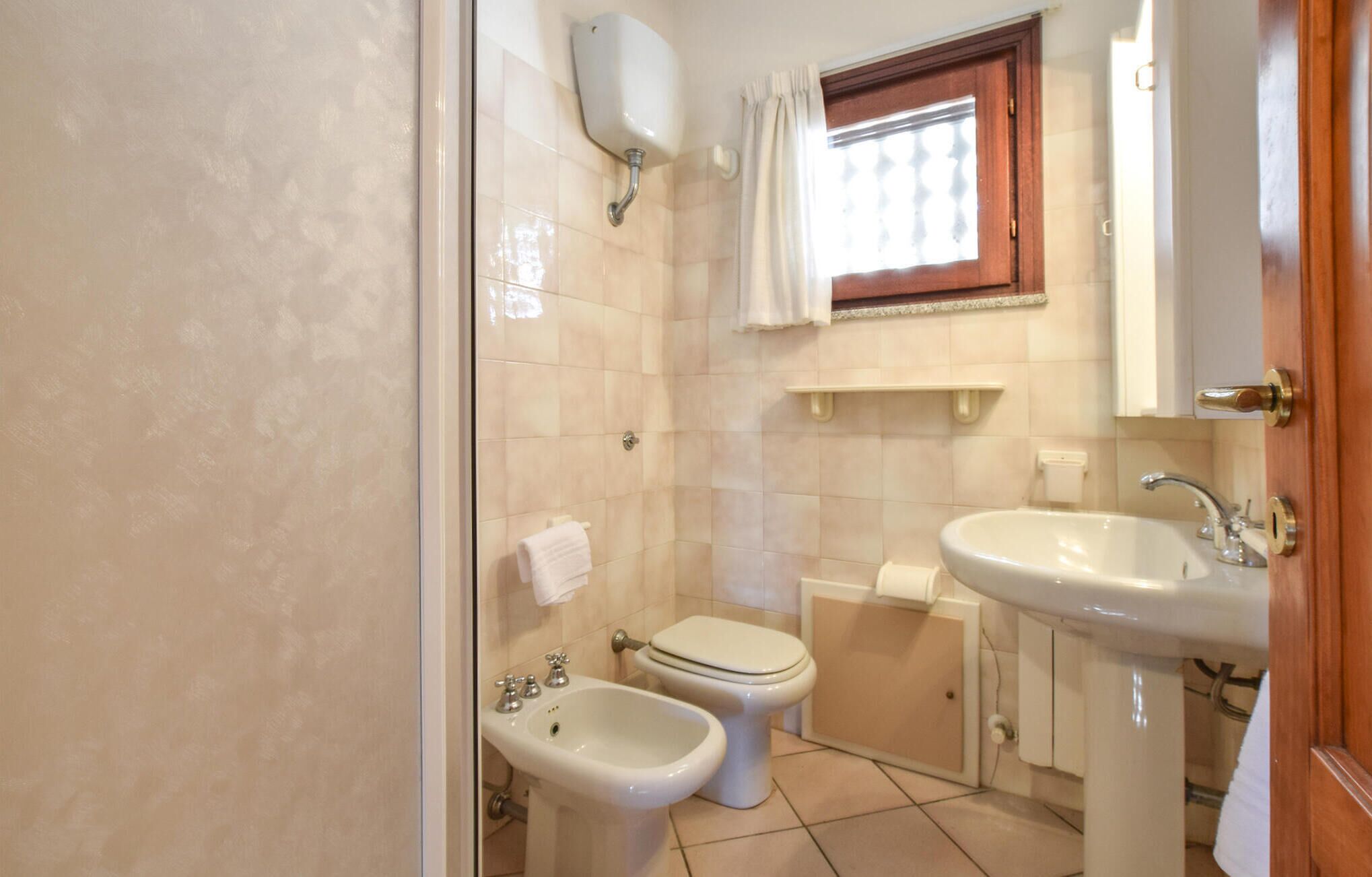 A bathroom with a toilet, bidet, and sink.