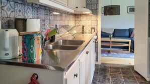 A kitchen with a double sink, white cabinets, a colorful spice rack, and a coffee maker. - Lovely home in Hishult with WiFi (Hishult)