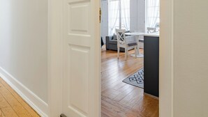 A hallway with a wooden floor leading to a dining area with a table and chairs. - Estúdio - Zona Histórica de Pombal (Pombal)
