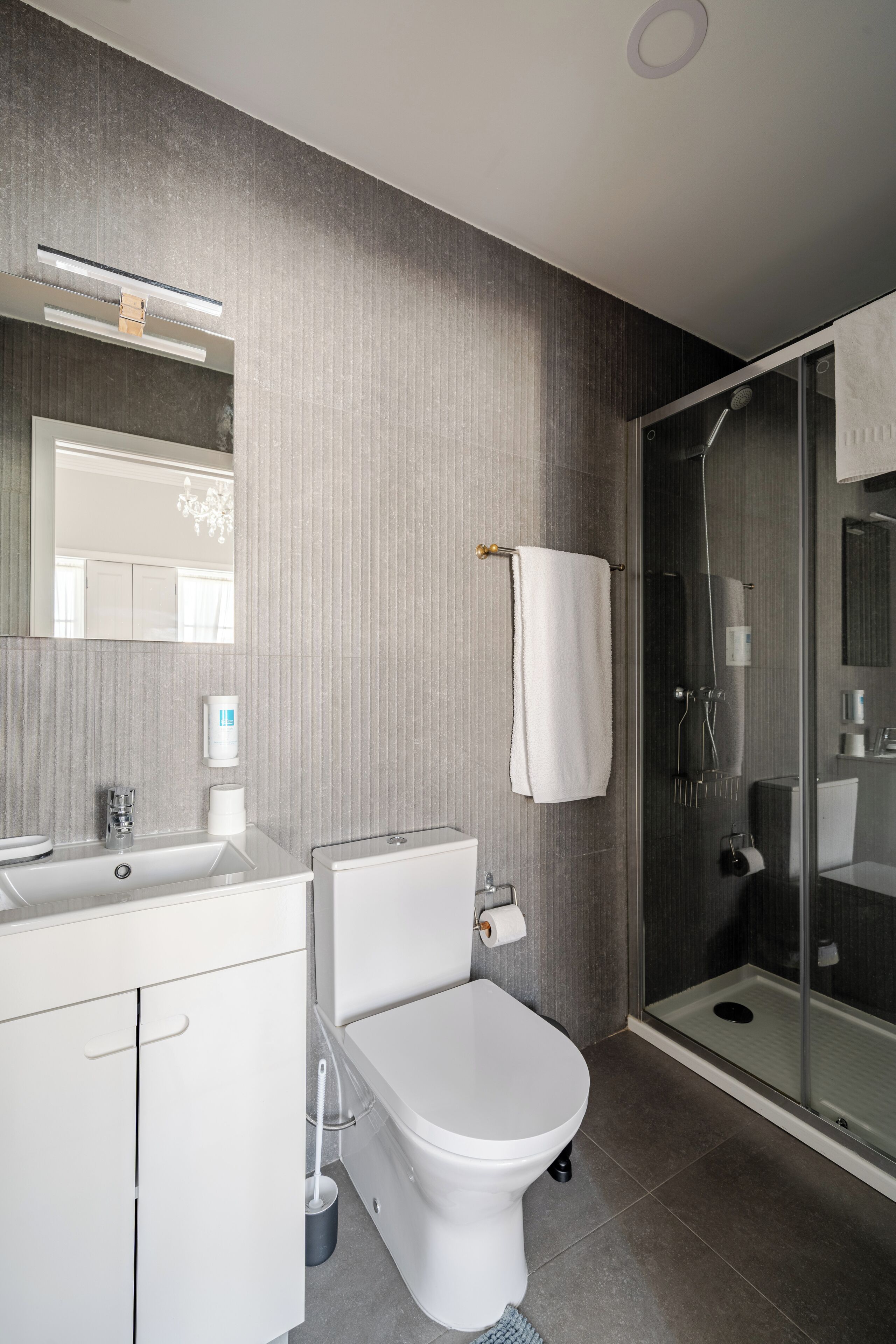 Un baño moderno con inodoro, lavabo y ducha.