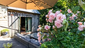 A rustic wooden building with a green door and steps leading up to it. - A quirky converted barn. (Cardigan)