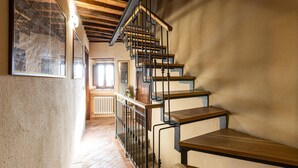 Eine Treppe mit hölzernen Stufen und schwarzen Metallgeländern, die zu einer oberen Etage führt.