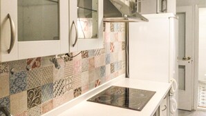 A kitchen with patterned tiles, a white countertop, and a built-in stove. - 4 bedroom cozy home in Brottby (Brottby)