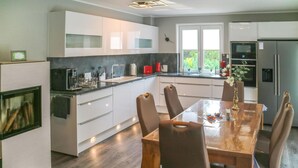Eine moderne Küche mit weißen Schränken, einem Holzespeisetisch und einem eingebauten Backofen.