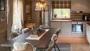 A cozy cabin-style kitchen with a wooden table, chairs, and a hanging light fixture. - Nice home in Rjukan with WiFi (Rjukan)