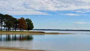 Ein ruhiger See mit Bäumen und blauem Himmel.