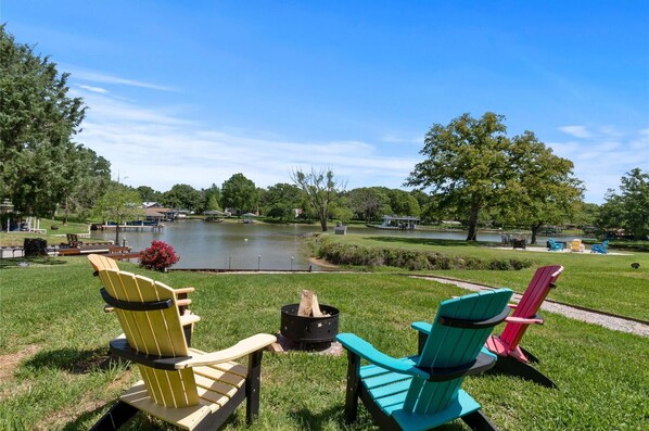 Une vue sur le lac, avec des fauteuils Adirondack et un foyer.