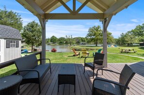 Une terrasse couverte avec des sièges et une vue sur un lac.