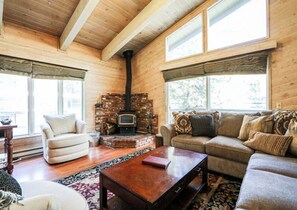 Cozy living room with a fireplace, comfortable sofa, and wooden coffee table.