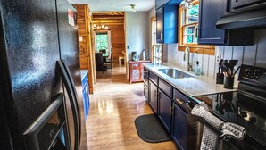 Cocina con gabinetes de madera, un refrigerador, un lavaplatos y una estufa.
