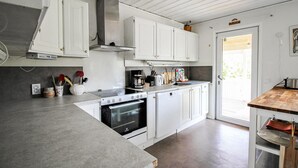 A modern kitchen with white cabinetry, a stainless steel range hood, and a built-in oven. - 6 bedroom pet friendly home in Vittaryd (Vittaryd)