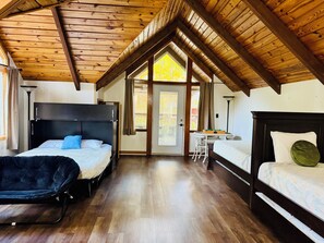 Quarto com duas camas, uma mesinha e uma cadeira.
