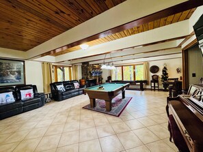 A spacious living room with a pool table, leather sofa, and a piano. - Christmas Fun~Hot Tub~Game Rm~@Ober Mtn (Gatlinburg)