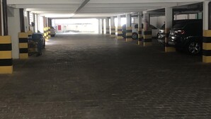 Un parking couvert avec un sol en briques et des piliers rayés.