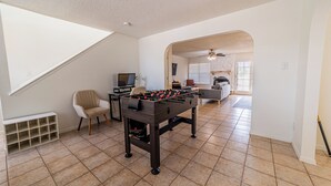 A spacious living room with a foosball table, a TV, and a comfortable seating area. - Modern Smart Townhouse | Premium Amenities | Nearby Restaurants | Full Kitchen (El Paso)