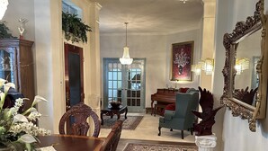 A dining room with a wooden table and chairs, a chandelier, and a large mirror on the wall. - Unwind and Relax 4 Bedroom Stay (Humble)