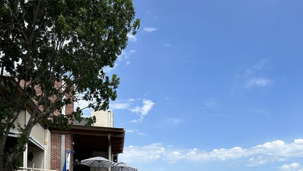 A waterfront restaurant with outdoor seating, a paved walkway, and a view of the water. - Unwind and Relax 4 Bedroom Stay (Humble)