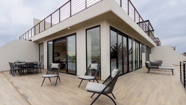A modern outdoor seating area with a pool table, lounge chairs, and a dining table. - Capitalia Downtown Del Valle (Mexico City)