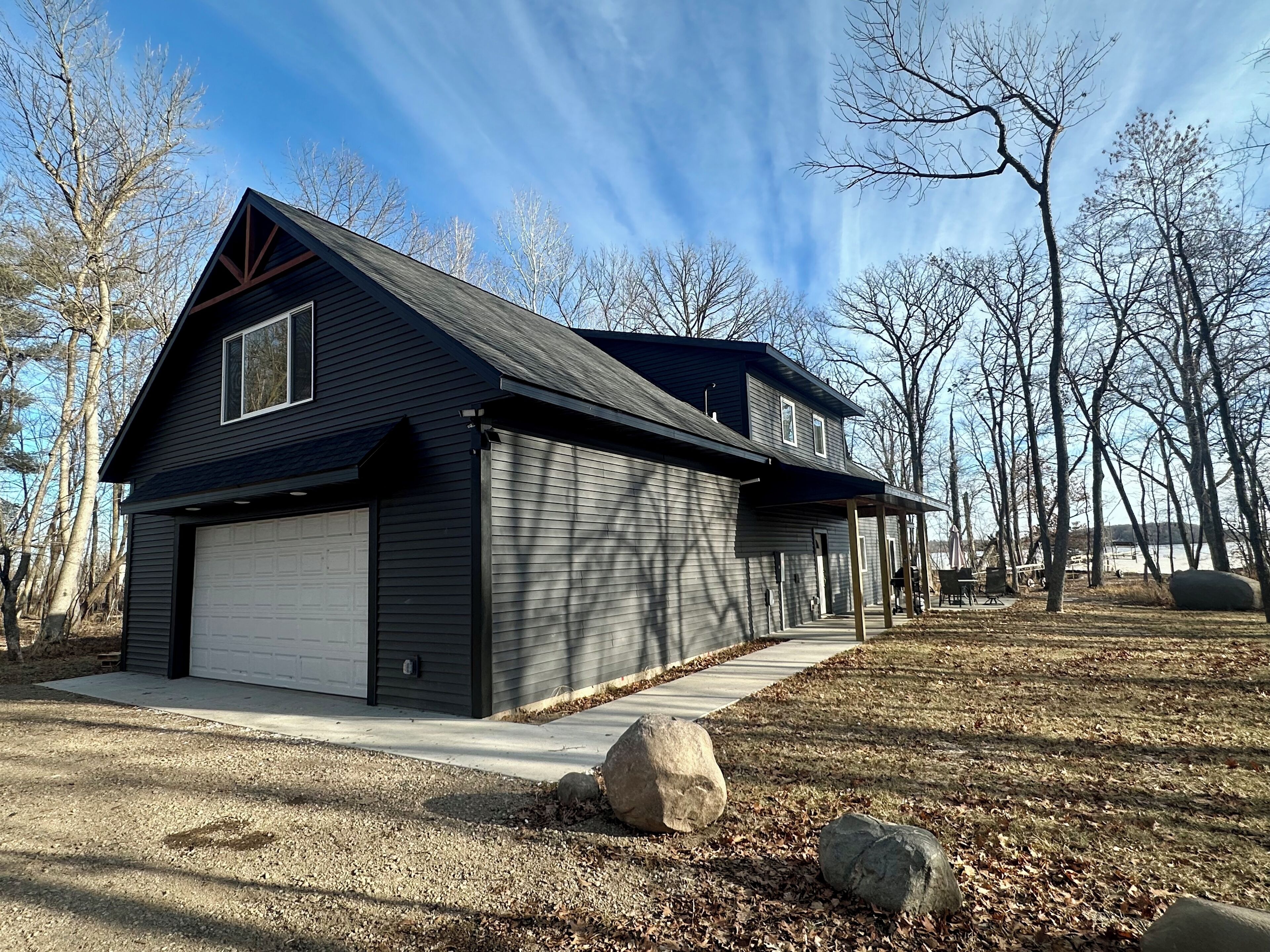 A two-story house with a garage, a covered porch, and a driveway.