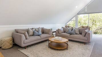 A modern living room with a sofa set, a coffee table, and a patterned rug.