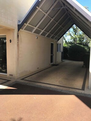 Un bâtiment doté d’une entrée couverte, d’une porte bien visible et du chiffre « 9 » peint sur le mur.
