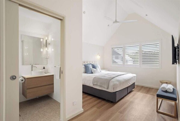 Une chambre à coucher avec un lit, une table de chevet et une fenêtre avec des stores.