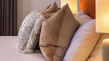 A bed with multiple pillows and a textured throw blanket.
