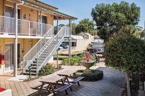 A building with a covered outdoor area, a staircase, and a parking lot. - Lana Studio—Central Base for South West Adventures (Margaret River)