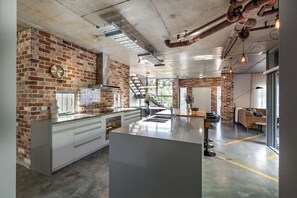 Een moderne keuken met een bakstenen muur, roestvrijstalen apparatuur en een centraal eiland.