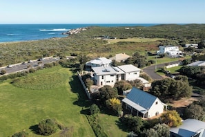 Zona residencial amb cases, un aparcament i vista a l'oceà.
