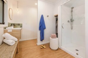 A bathroom with a shower, a sink, a mirror, and a towel rack. - Mika Cabin—Breezy Family Haven, Easy Walk to Beach (Eagle Bay)
