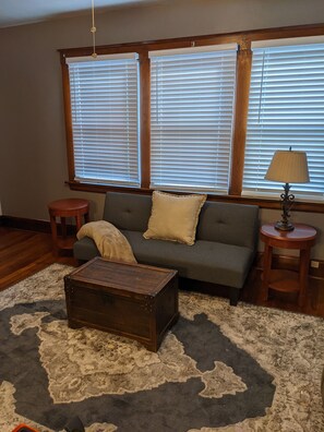 Relax in this inviting living room with a sofa, coffee table, and side table, surrounded by natural light and a comfortable rug.