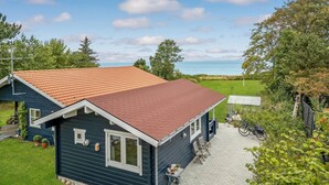 A two-story house with a red-tiled roof, a covered patio, and a view of the sea. - Awesome home in Kalundborg with WiFi (Kalundborg)