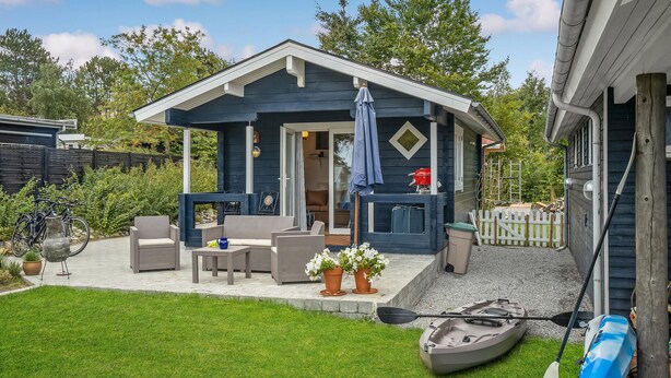 A cozy outdoor seating area with wicker furniture, a barbecue grill, and potted plants. - Awesome home in Kalundborg with WiFi (Kalundborg)