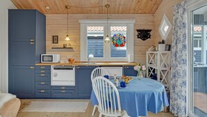 A compact kitchen with wooden cabinets, a microwave, a sink, and a window with a colorful stained glass design. - Awesome home in Kalundborg with WiFi (Kalundborg)